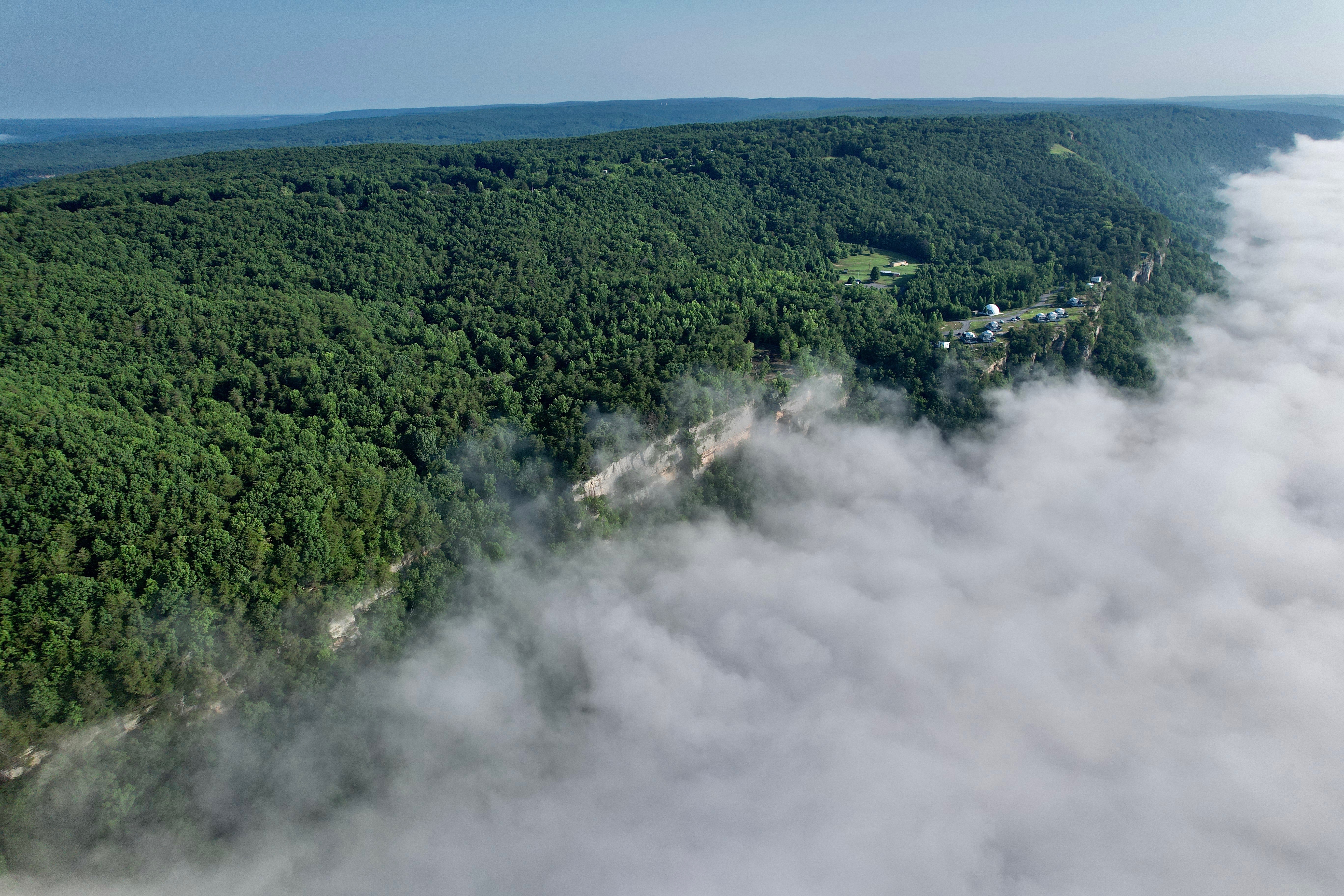 Aerial view of Bolt Mountain with clouds drifting over forested ridges above the domes