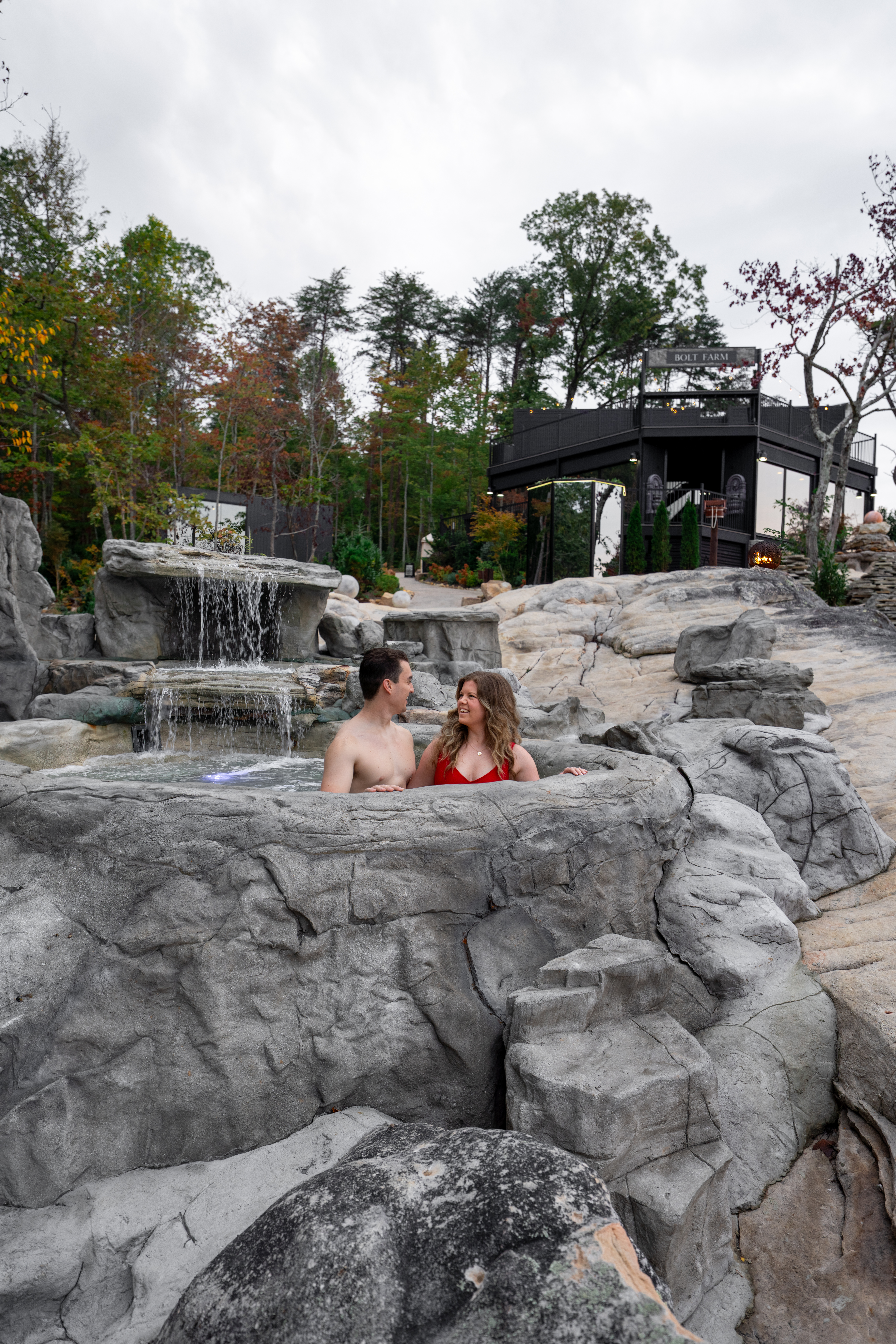 Private outdoor soaking tub on the Mirror cabin deck, water steaming, surrounded by tall trees