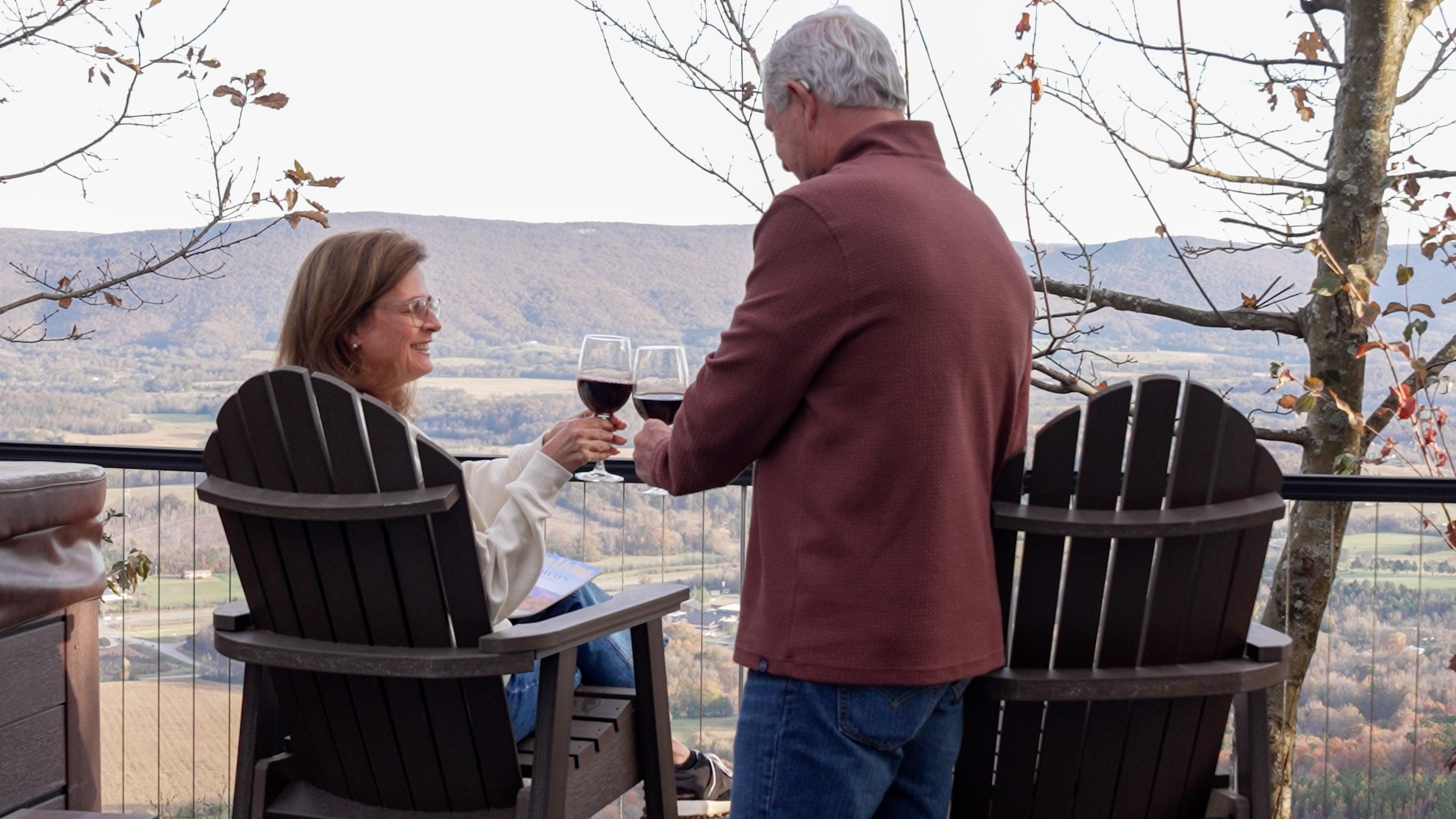 Couple relaxing together on a treehouse cabin porch at BOLT FARM Treehouse
